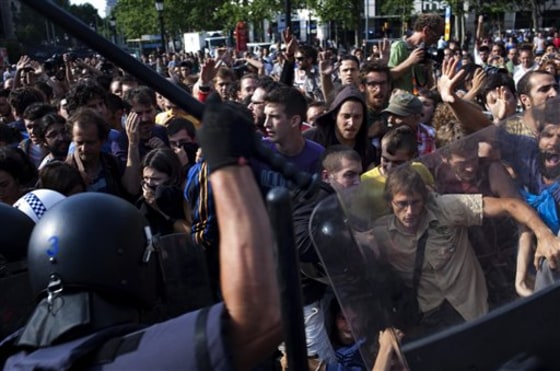 Riot police disperse demonstrators during clashes in Barcelona, Spain, on Friday.